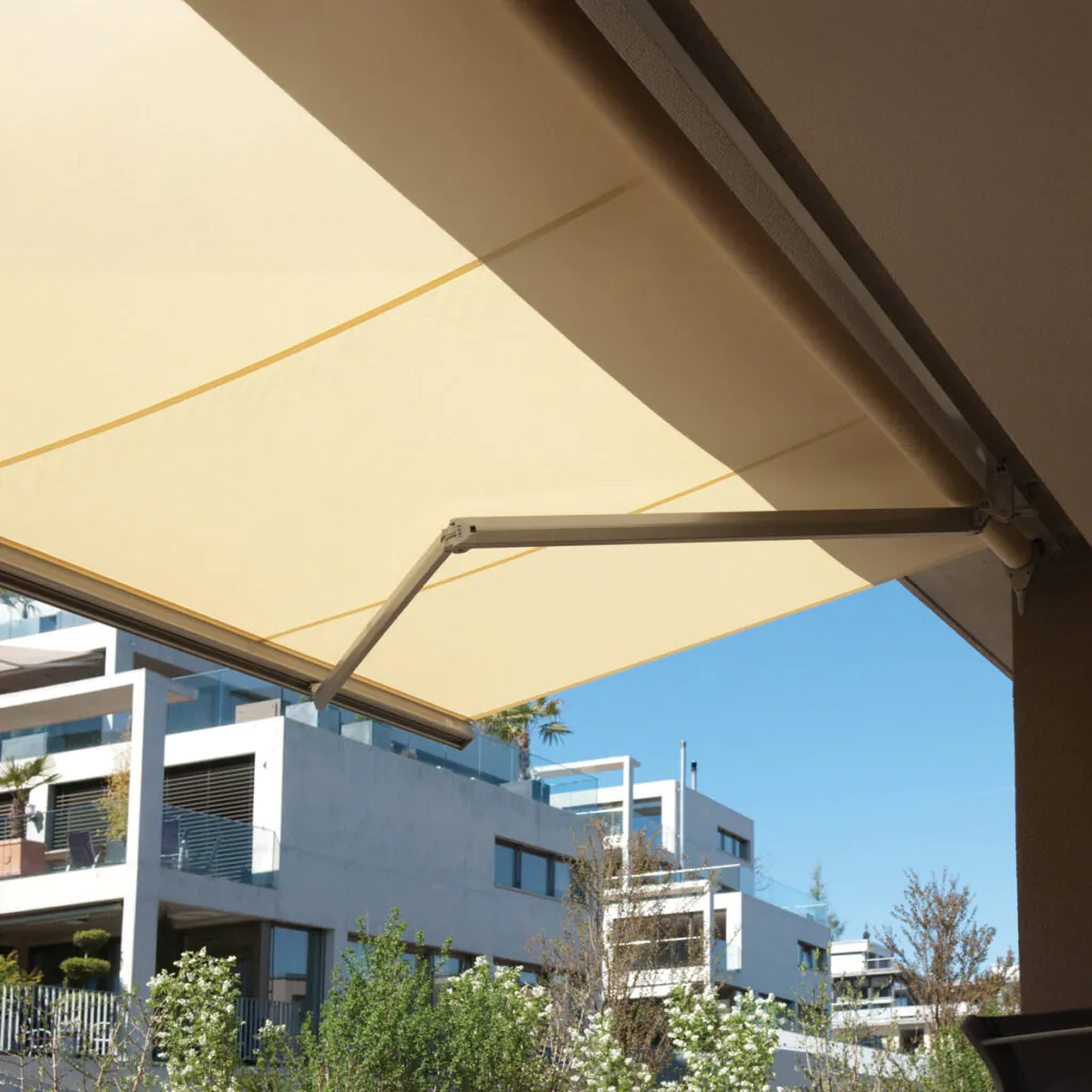 Vista interna de uma varanda protegida do sol por toldo Azur