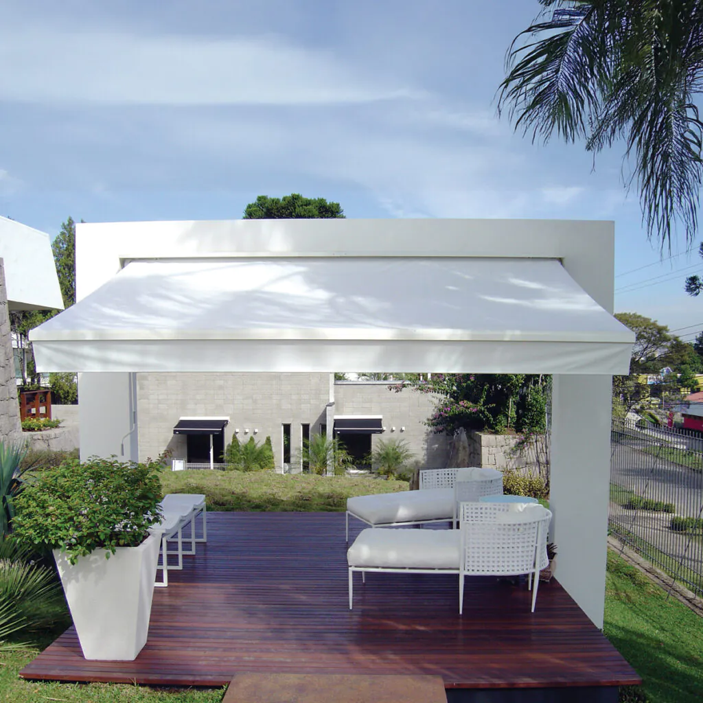 Toldo Azur retrátil instalado em deque de madeira com vista para o jardim
