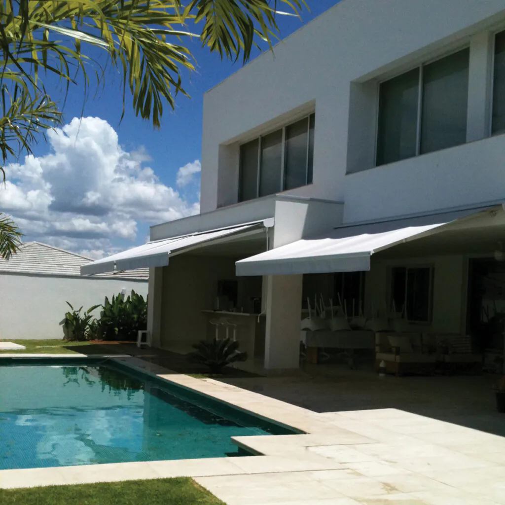 Toldo Azur aplicado em residência com piscina e área gourmet integrada