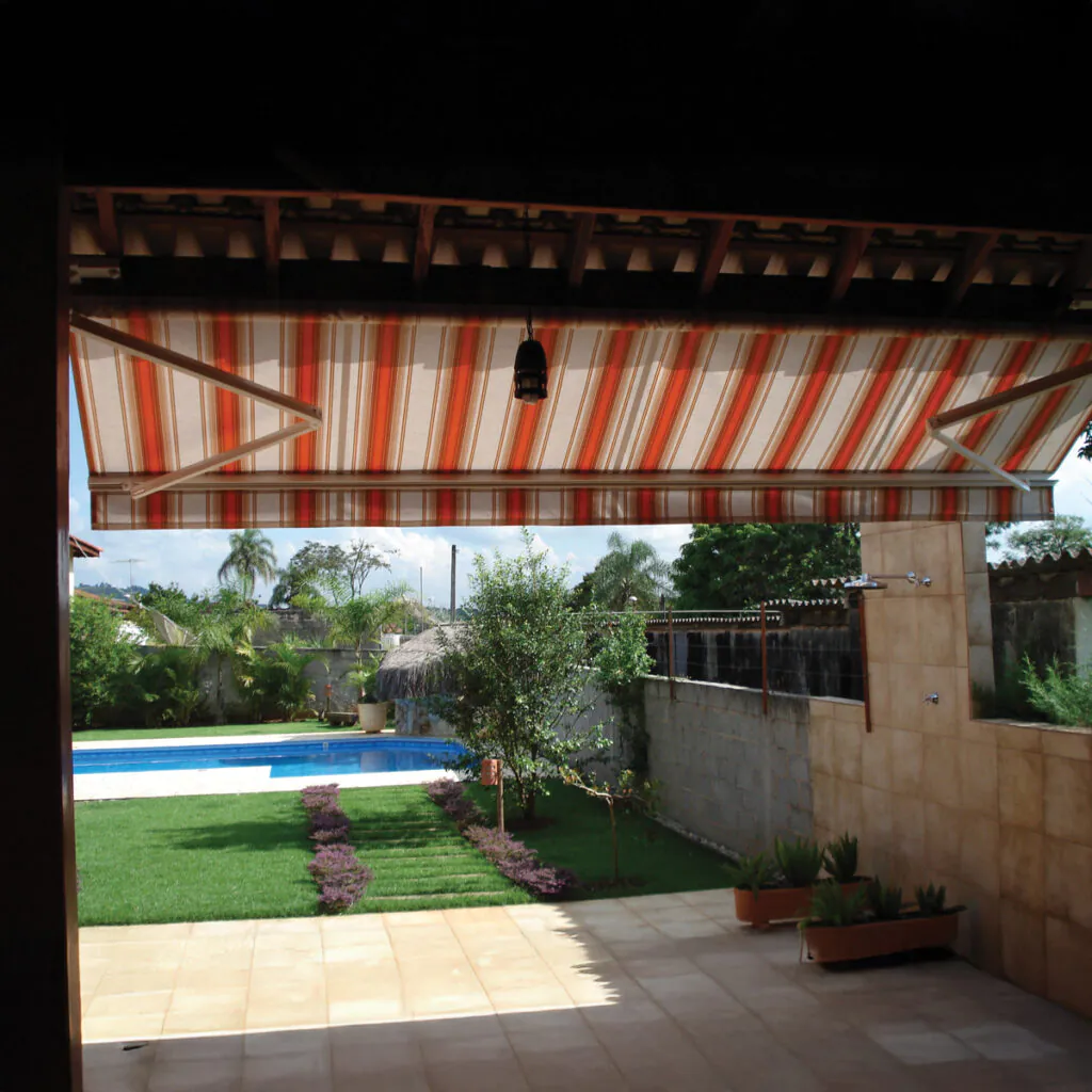 Toldo Delta-flex retrátil da Stobag instalado em área de piscina