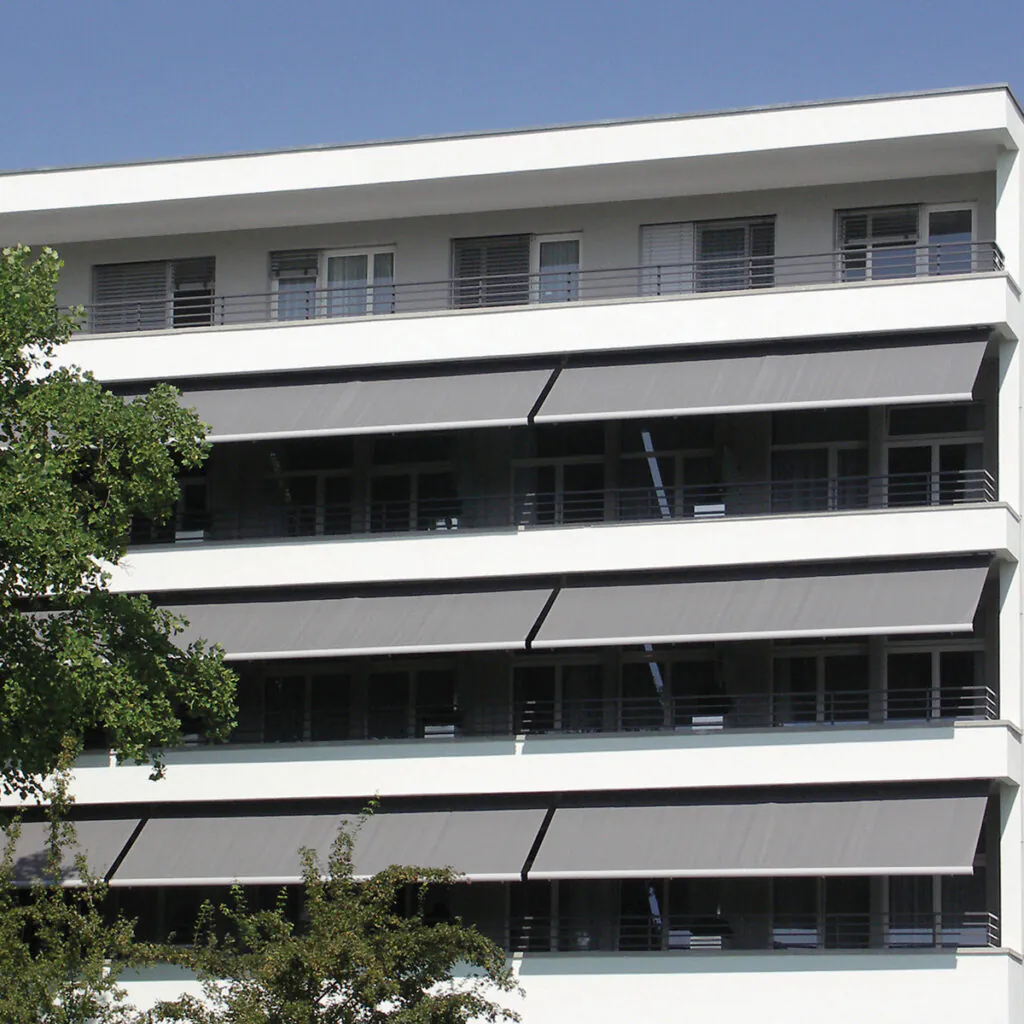 Toldos de braços retráteis aplicados em fachada de prédio residencial