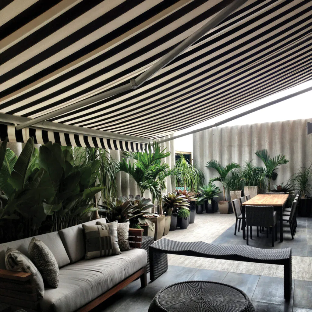 Toldos de braços retráteis para sombra com estilo instalados em varanda com mobiliário externo elegante