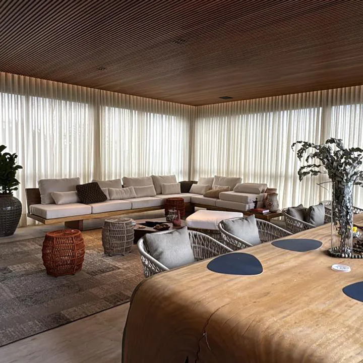 Sala ampla com teto ripado e cortinas de tecido claras instaladas pela Copato