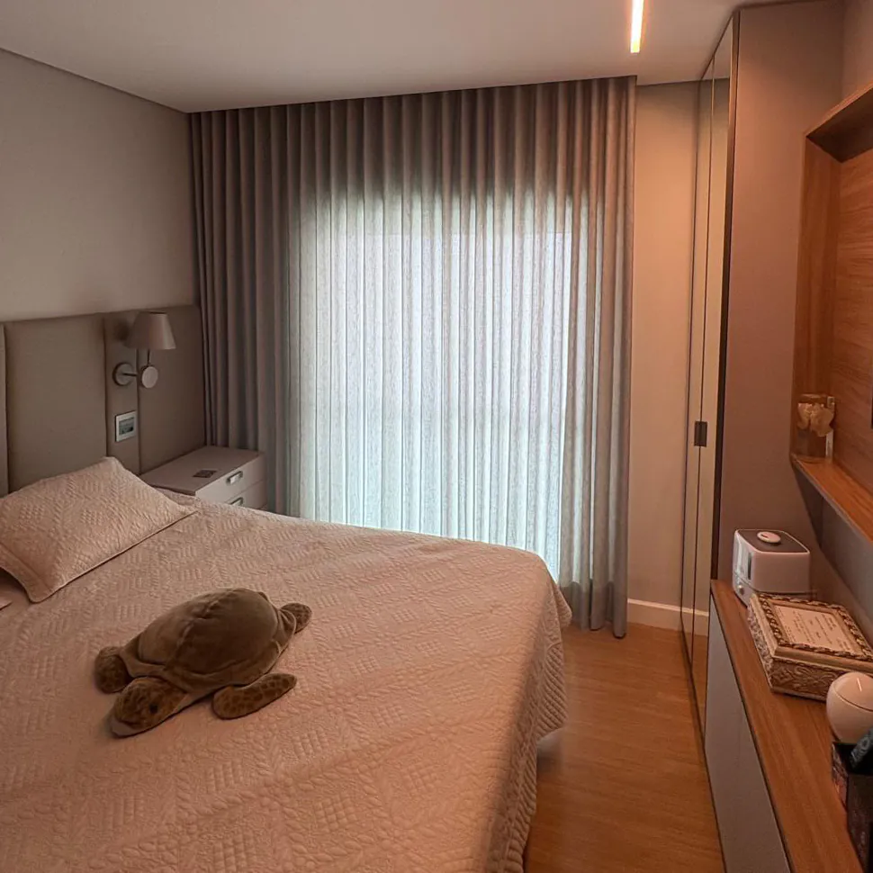 Quarto de casal com cortina de tecido cinza claro do piso ao teto e painel de madeira