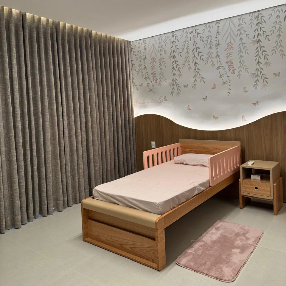 Quarto infantil com cortina de tecido cinza e papel de parede floral, instalado com projeto da Copato.