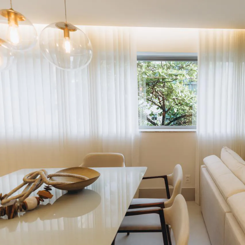 Cortina de tecido leve em sala de jantar com janela central, instalada com acabamento sob medida pela Copato