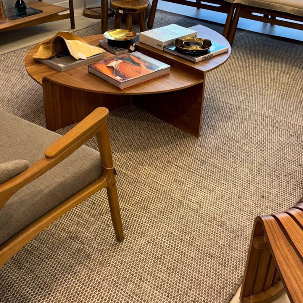 Tapete de trama grossa sob medida em sala com mobiliário em madeira e estofado bege, solução decorativa da Copato.