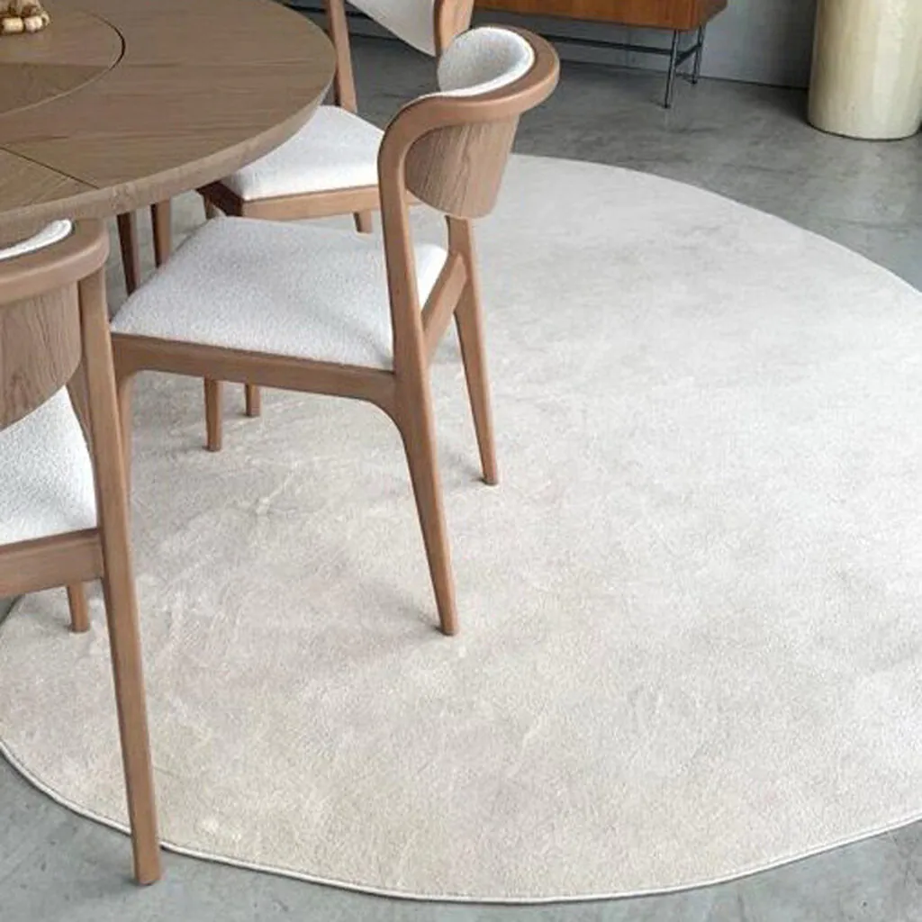 Tapete redondo claro personalizado sob medida, instalado em sala de jantar contemporânea com mobiliário de madeira clara, solução da Copato.