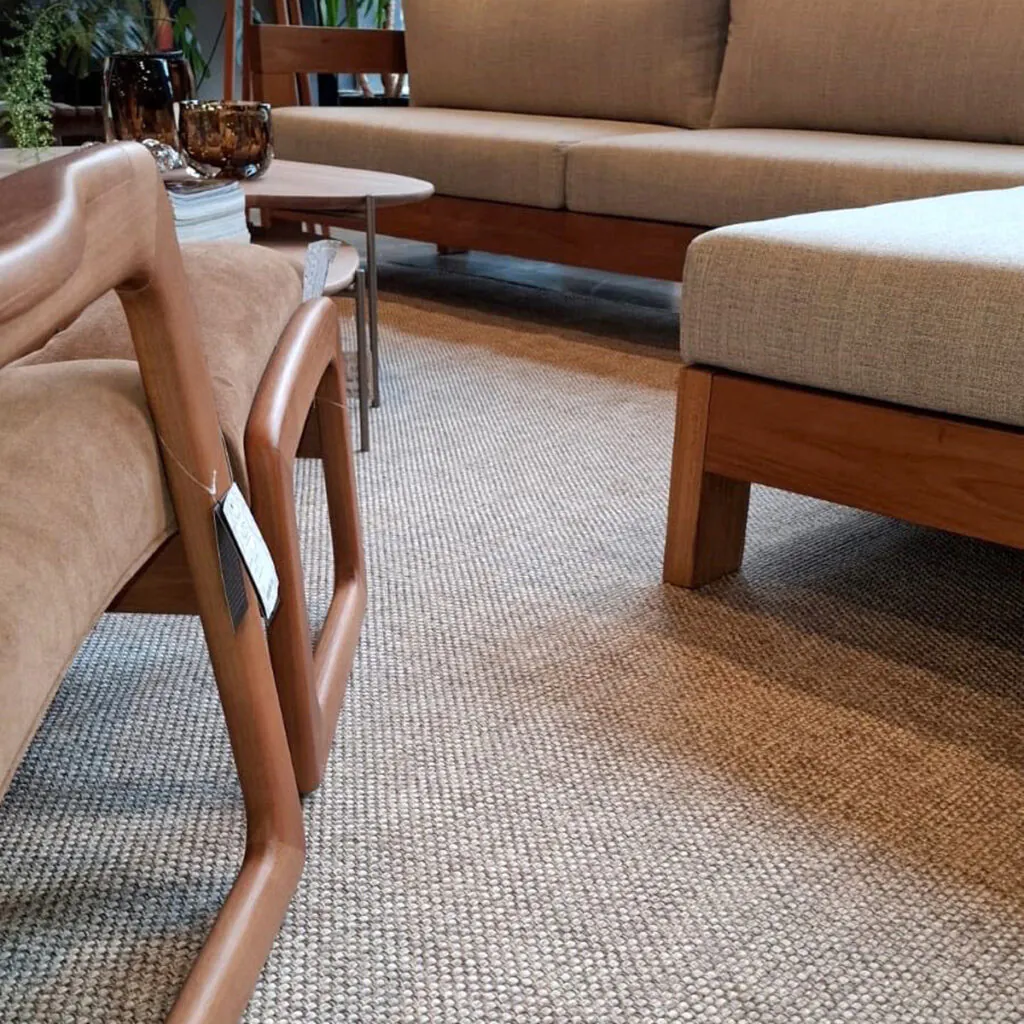 Tapete de textura natural instalado em sala com mobiliário de madeira e estofados claros, projeto sob medida da Copato.